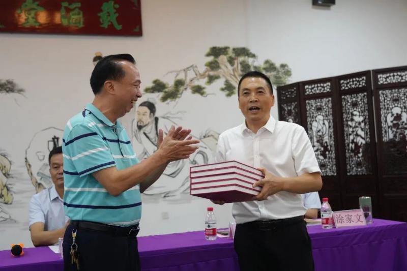 中共儋州市委宣传部常务副部长梁定中，儋州市老年书画家协会主席吴博雄向我校赠送书画作品及画册